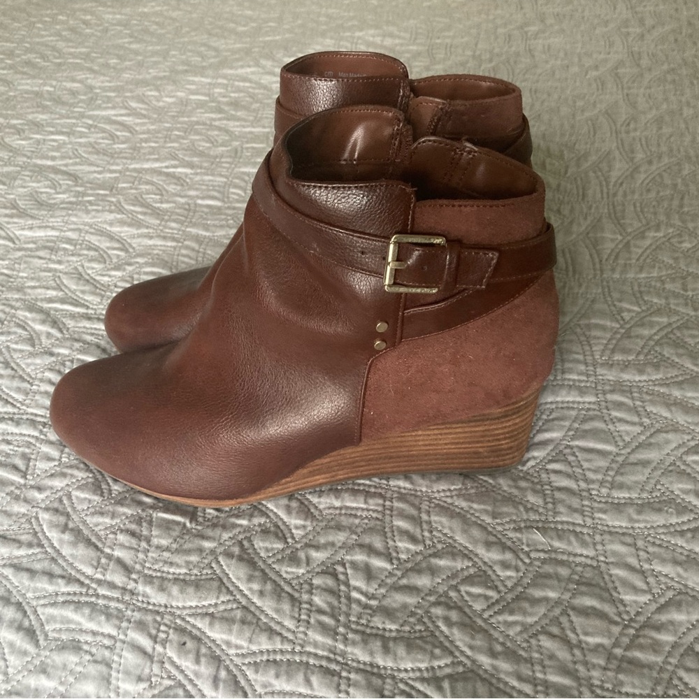 Brown ankle boots with zipper and gold accents.